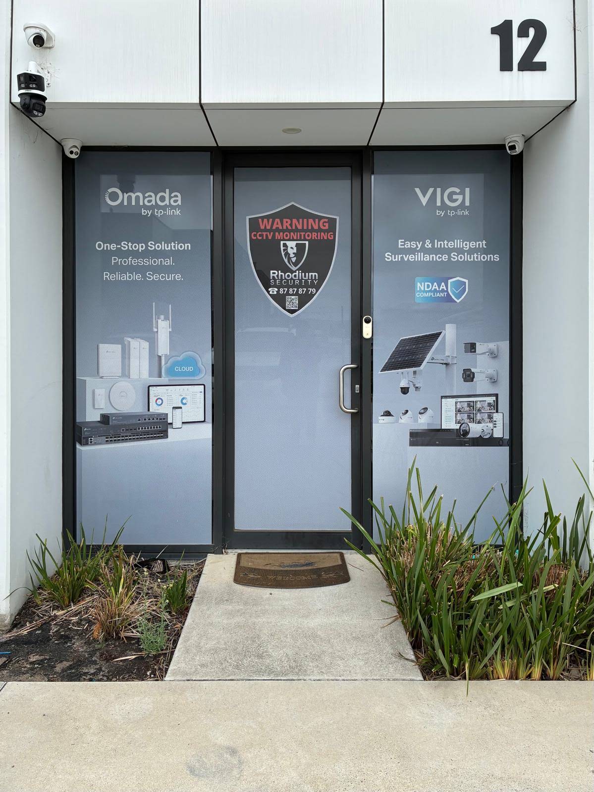 Number 12 above the entrance, with Rhodium Security signage on the glass door.